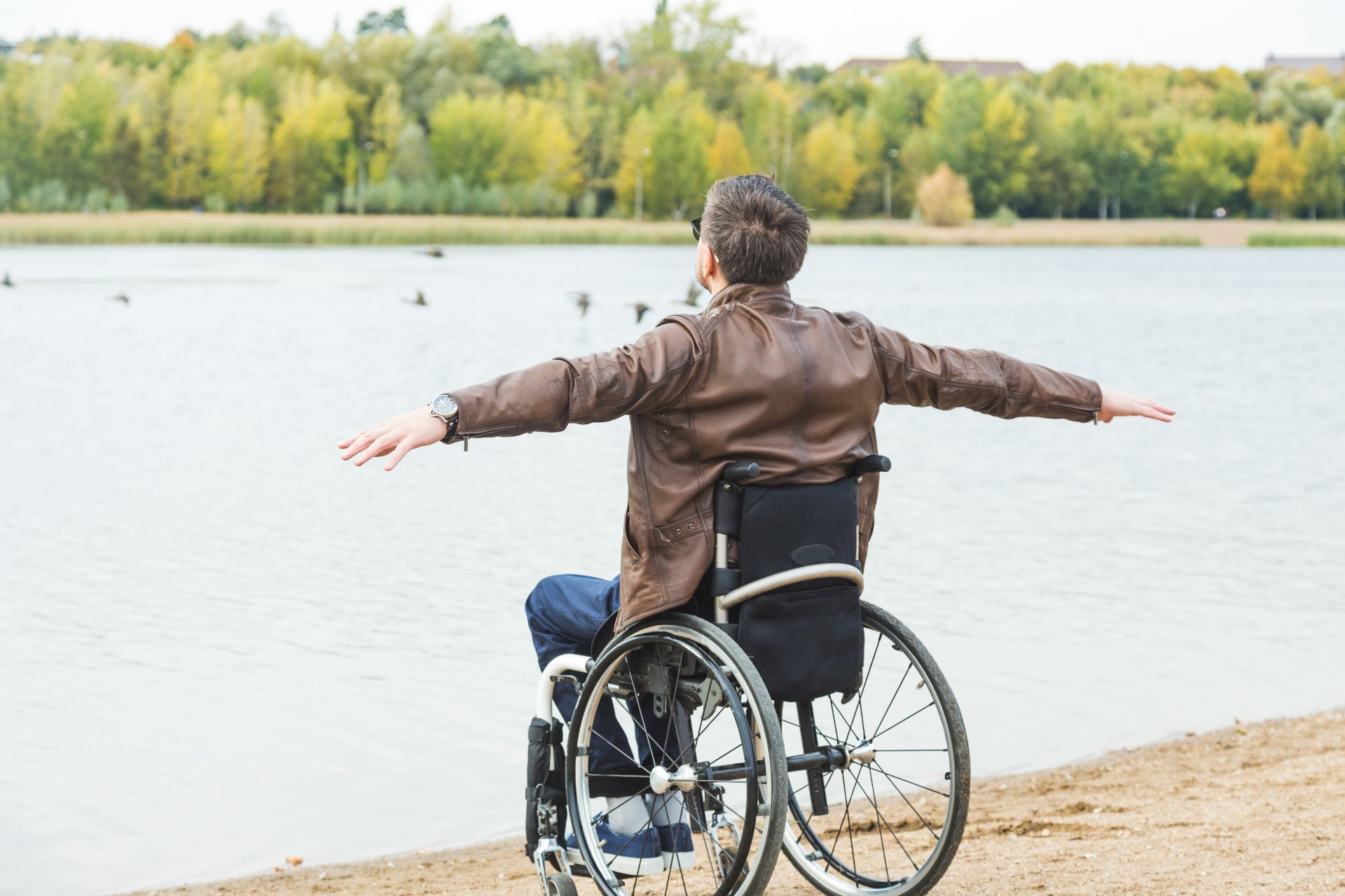 Čovjek u invalidskim kolicima kraj jezera